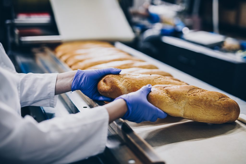 Woman working on production line according to food defence plan